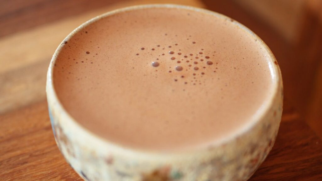 Warmer Cacao in einer handgetöpferten Schale auf einem Holztisch